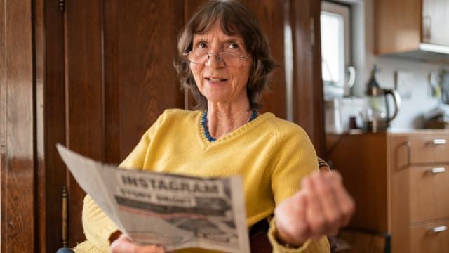 Aleida Assmann mit einer Zeitung in der Hand. Aleida Assmann mit einer Zeitung in der Hand.