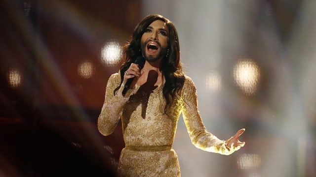 Conchita Wurst mit Bart und langen Haaren und goldenem Kleid. Conchita Wurst mit Bart und langen Haaren und goldenem Kleid.