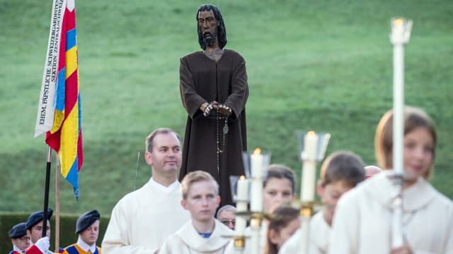 Ein Festgottesdienst zu Ehren von Niklaus von Flue. Gläubige tragen eine Statue von Bruder Klaus. Ein Festgottesdienst zu Ehren von Niklaus von Flue. Gläubige tragen eine Statue von Bruder Klaus.