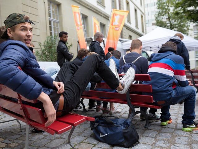 Junge Leute auf einer Bank sitzend.