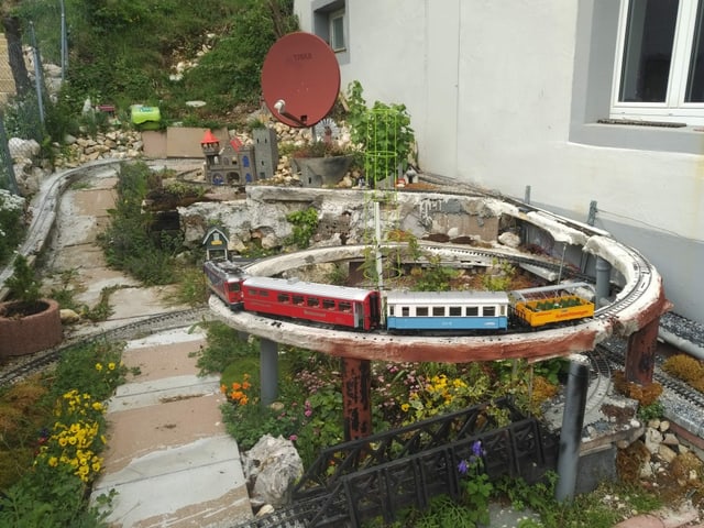 Garten mit Modelleisenbahn als Blickfang.