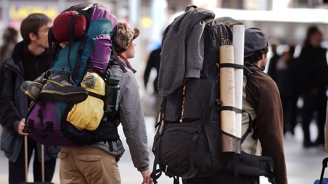 Zwei Rucksacktouristen ziehen durch die Strasse. Zwei Rucksacktouristen ziehen durch die Strasse.