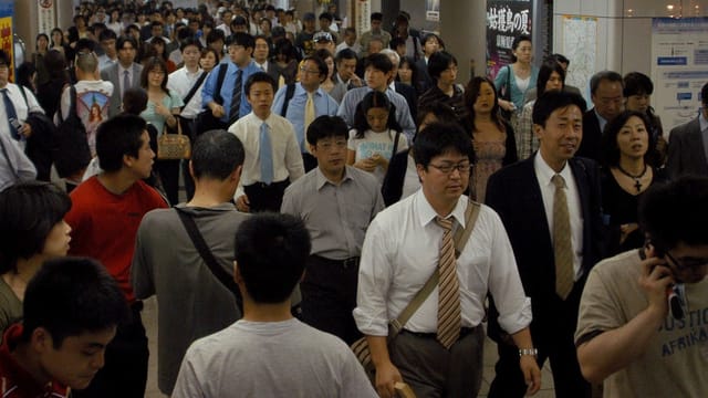 Menschen gehen durch die Gänge der U-Bahn in Tokio. Menschen gehen durch die Gänge der U-Bahn in Tokio.