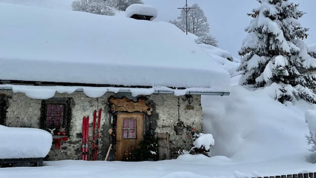 Eine Hütte versinkt fast im vielen Neuschnee. Eine Hütte versinkt fast im vielen Neuschnee.