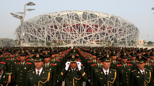 Eine Aussenaufnahme des Stadions in Peking, davor eine Militärparade. Eine Aussenaufnahme des Stadions in Peking, davor eine Militärparade.