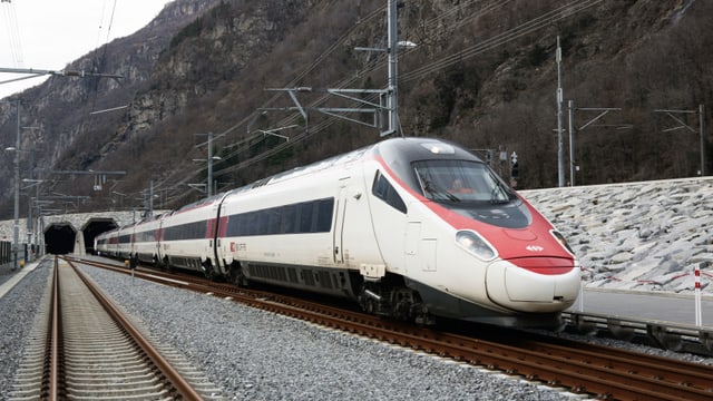 Ein rot-weisser Zug fährt aus dem Gotthard-Tunnel heraus. Ein rot-weisser Zug fährt aus dem Gotthard-Tunnel heraus.