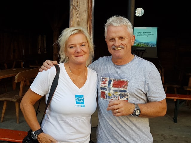 Eine Frau und ein Mann vor einem Chalet.