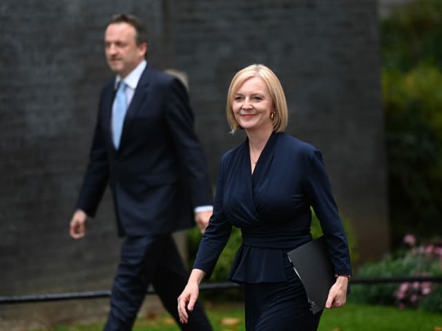 Liz Truss walks in, her husband behind her