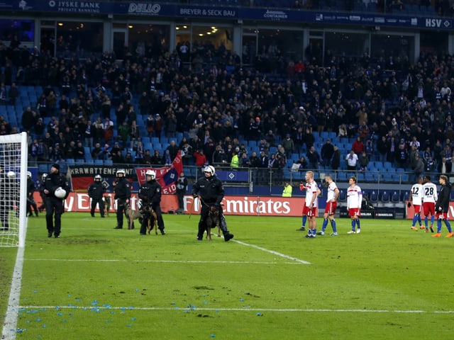 Polizisten mit Hunden vor HSV-Spielern auf dem Rasen. Polizisten mit Hunden vor HSV-Spielern auf dem Rasen.