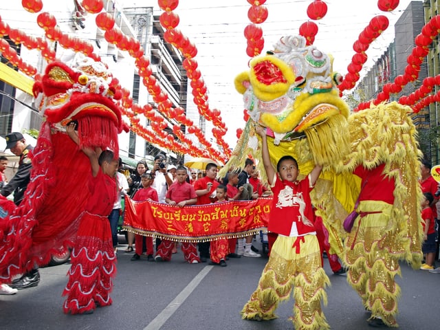 Chinesen tanzen mit Drachen auf der Strasse