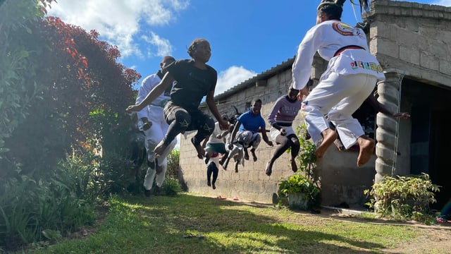 Schüler hüpfen beim Taekwondo-Training hoch in die Luft Schüler hüpfen beim Taekwondo-Training hoch in die Luft