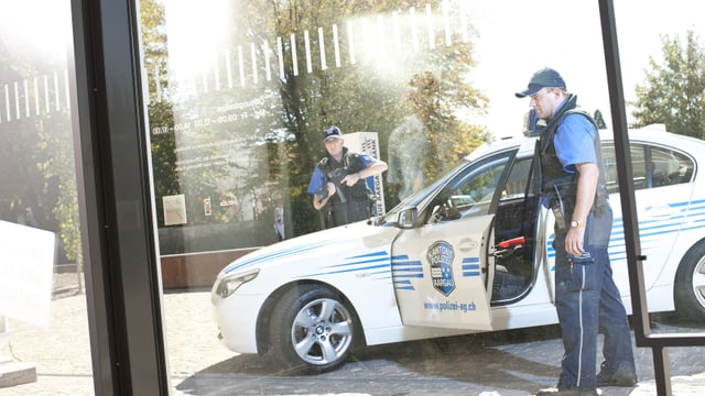 Polizisten vor Polizeiauto. Polizisten vor Polizeiauto.