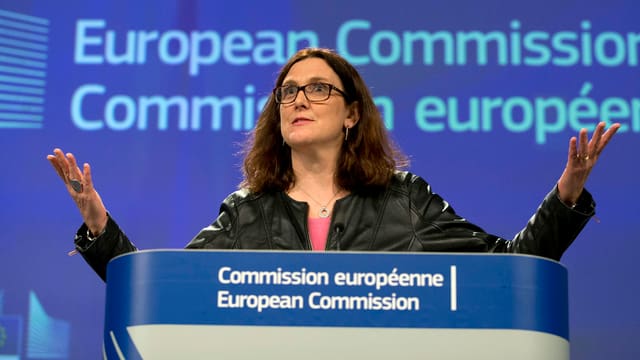 Frau mit Brille und dunklen langen Haaren an Stehpult. Frau mit Brille und dunklen langen Haaren an Stehpult.