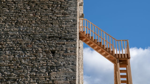 Eine Holztreppe an der Fassade eines Steinturms. Eine Holztreppe an der Fassade eines Steinturms.