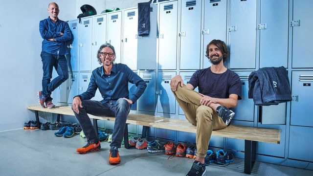 Drei Männer sitzen in einer Garderobe Drei Männer sitzen in einer Garderobe