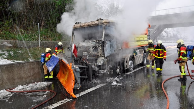 Feuerwehrleute löschen einen Brand an einem Fahrzeug. Feuerwehrleute löschen einen Brand an einem Fahrzeug.