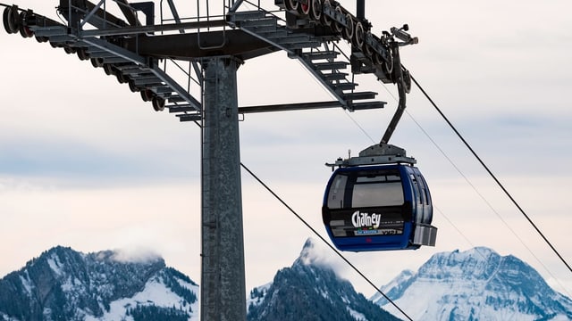 Gondelbahn mit Aufschrift Charmey, Seilmast, im Hintergrund Berge Gondelbahn mit Aufschrift Charmey, Seilmast, im Hintergrund Berge