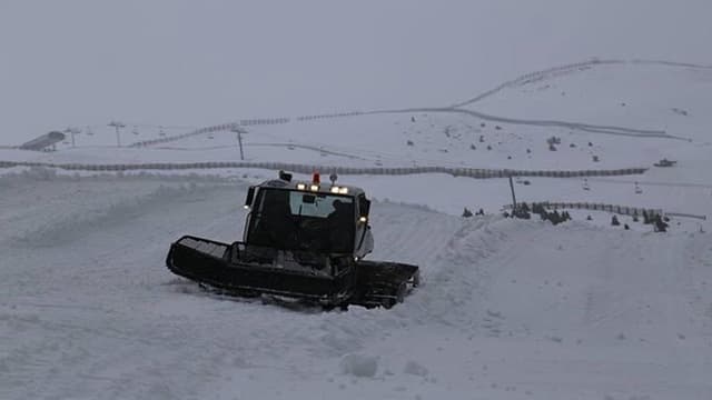 Ein Pistenraupen-Fahrzeug fährt durch den Schnee. Ein Pistenraupen-Fahrzeug fährt durch den Schnee.