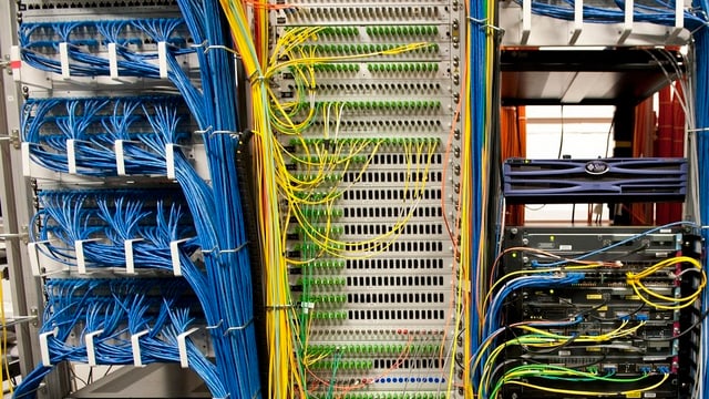 Zu sehen ist ein Serverraum mit vielen Kabeln. Zu sehen ist ein Serverraum mit vielen Kabeln.