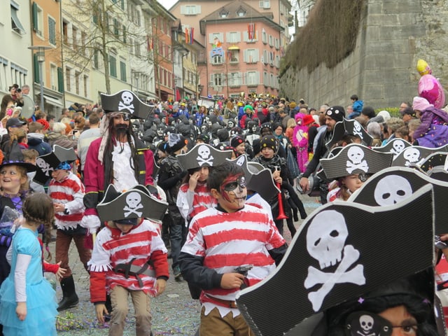Eine Meute von Kindern in Indianerkostümen stürmen durch die Altstadt