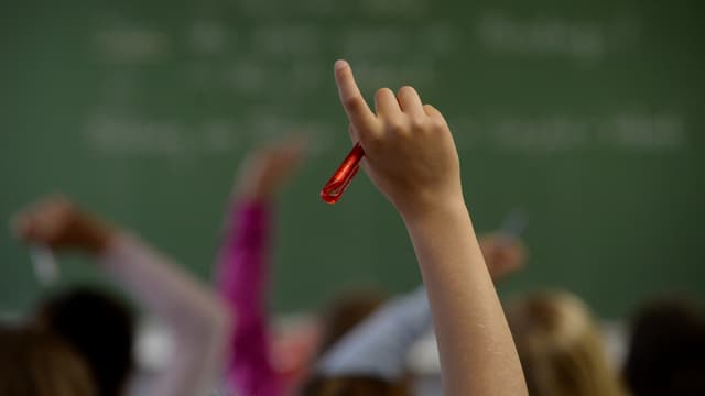 Ein Kind streckt die Hand in die Höhe. Ein Kind streckt die Hand in die Höhe.