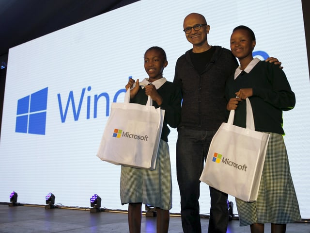 Satya Nadella auf einer Bühne zusammen mit zwei Schülerinnen. Satya Nadella auf einer Bühne zusammen mit zwei Schülerinnen.