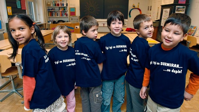 Kinder mit einem blauen T-Shirt in einem Schulzimmer