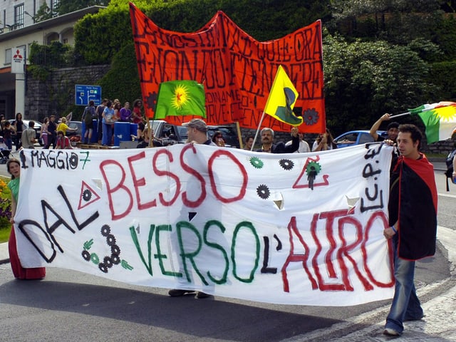 Demonstraten auf der Strasse, die ein grosses Transparent vor sich hertragen. Demonstraten auf der Strasse, die ein grosses Transparent vor sich hertragen.