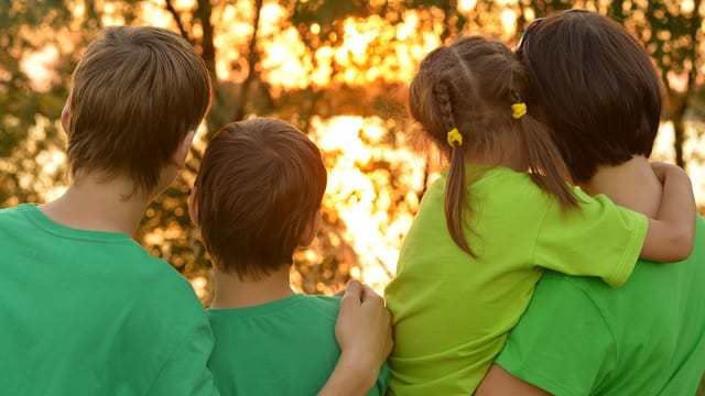 Kinder mit Mutter blicken in den Sonnenuntergang Kinder mit Mutter blicken in den Sonnenuntergang