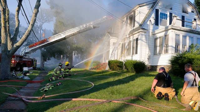 Feuerwehrleute an einem qualmenden Haus Feuerwehrleute an einem qualmenden Haus