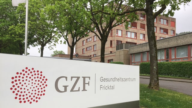 Logo Spitalzentrum, dahinter Spitalgebäude. Logo Spitalzentrum, dahinter Spitalgebäude.