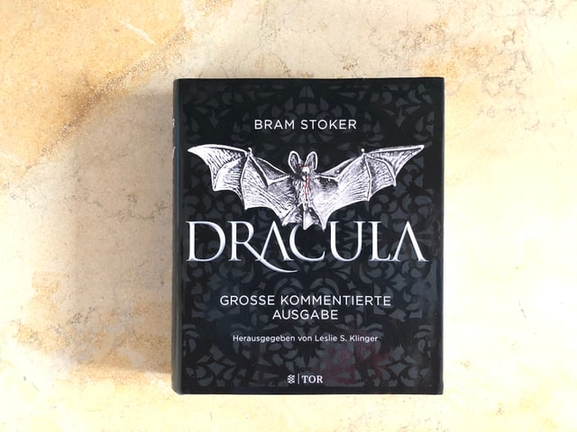 Der Roman «Dracula» von Bram Stoker liegt auf einer Marmorplatte Der Roman «Dracula» von Bram Stoker liegt auf einer Marmorplatte