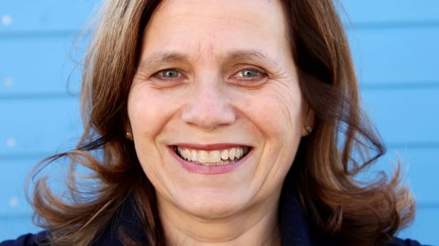 Eine Frau vor einer blauen Fassade. Eine Frau vor einer blauen Fassade.