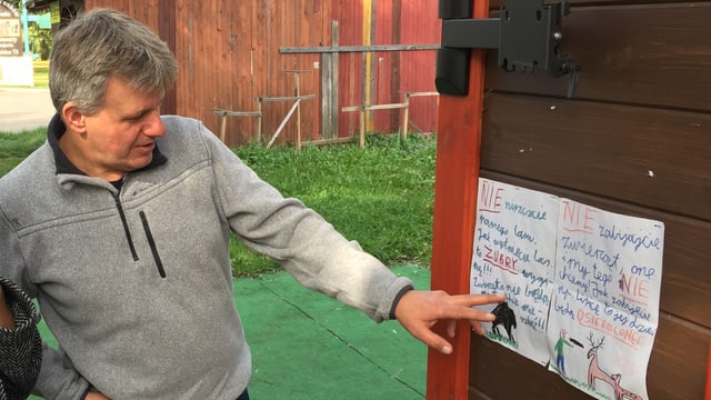 Mann zeigt auf Kinderzeichnung an Wand. Mann zeigt auf Kinderzeichnung an Wand.