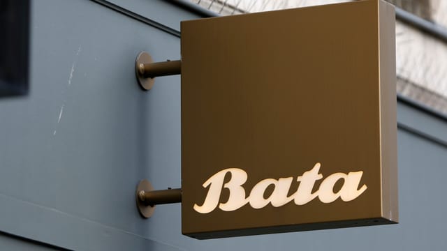 Braunes Schild mit der Aufschrift "Bata" ragt aus einer Hauswand eines Schuhgeschäfts Braunes Schild mit der Aufschrift "Bata" ragt aus einer Hauswand eines Schuhgeschäfts