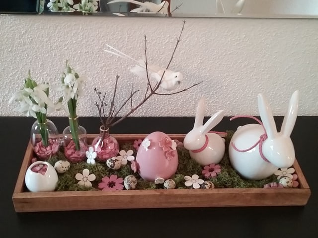 Kleines Arrangement mit weissen und rosafarbenen Osterhasen udn Eiern aus Porzellan.