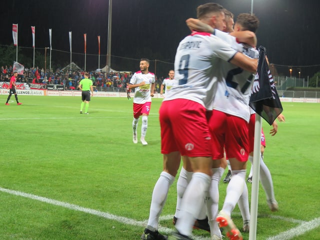Drei Spieler umarmen sich nach einem Tor Drei Spieler umarmen sich nach einem Tor