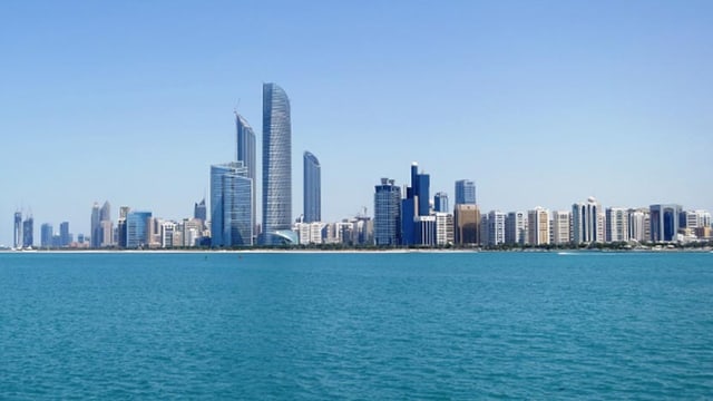 Man sieht hinter einem Streifen Meer eine Skyline aus Hochhäusern. Man sieht hinter einem Streifen Meer eine Skyline aus Hochhäusern.