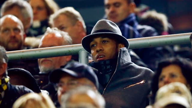 BVB-Torjäger Pierre-Emerick Aubameyang auf der Tribüne mit Mantel und Hut. BVB-Torjäger Pierre-Emerick Aubameyang auf der Tribüne mit Mantel und Hut.