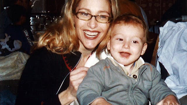 Isabelle Neulinger hat ihren Sohn auf der Schoss, beide lächeln in die Kamera.