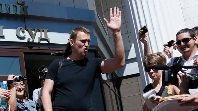 Nawalny beim Verlassen des Gerichtssaals, daneben Journalisten.