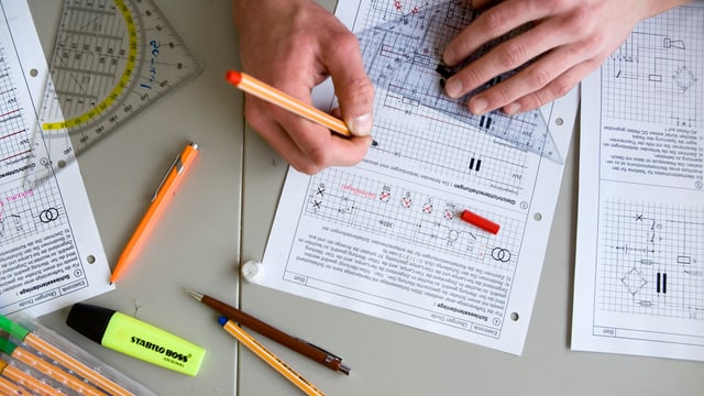 Die Hände eines Schülers. Er arbeitet an einer technischen Zeichnung. Die Hände eines Schülers. Er arbeitet an einer technischen Zeichnung.