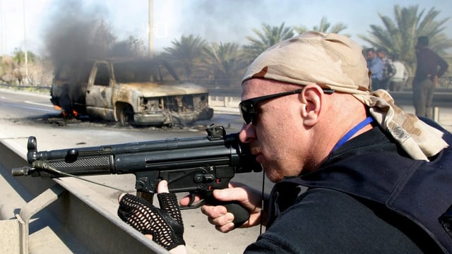 Ein Söldner sichert 2004 in Bagdad mit angeschlagenem Gewehr den Ort eines Anschlags. Ein Söldner sichert 2004 in Bagdad mit angeschlagenem Gewehr den Ort eines Anschlags.