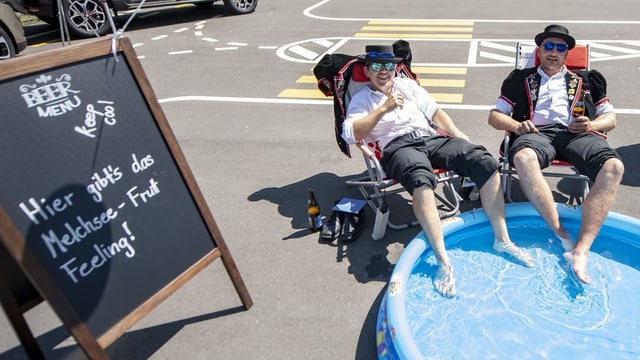 Zwei Männer, welche ihre Füsse in einem Babybassin baden. Zwei Männer, welche ihre Füsse in einem Babybassin baden.