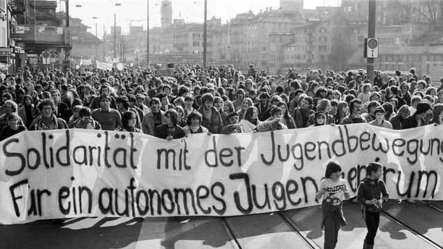 Menschenmenge läuft durch Zürich mit Transparenten Menschenmenge läuft durch Zürich mit Transparenten