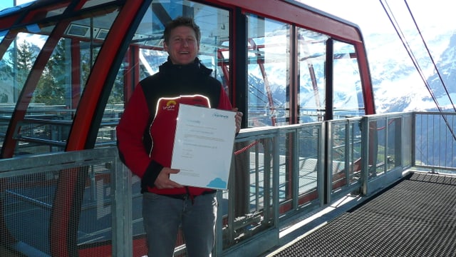 Mann vor einer Bergbahn-Gondel Mann vor einer Bergbahn-Gondel
