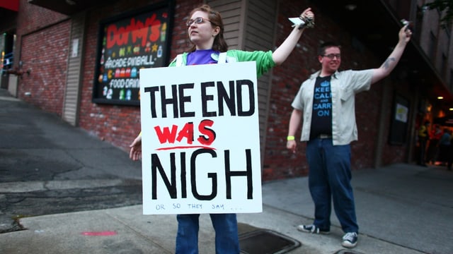Eine Frau mit einem Schild auf der Brust. Dort steht «The end was nigh» (keystone/archiv) Eine Frau mit einem Schild auf der Brust. Dort steht «The end was nigh» (keystone/archiv)