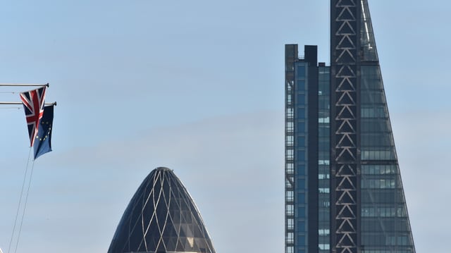 Zwei Wolkenkratzer neben einer EU- und einer Grossbritannien-Flagge. Zwei Wolkenkratzer neben einer EU- und einer Grossbritannien-Flagge.