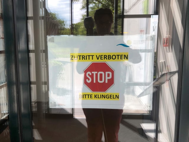 Eine Person steht vor einer verschlossenen Glastüre mit der Aufschrift STOPP. Eine Person steht vor einer verschlossenen Glastüre mit der Aufschrift STOPP.
