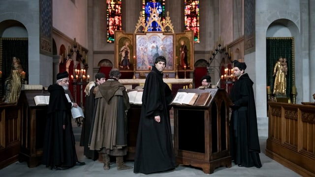 Mehrere Pfarrer stehen in einer Kirche Mehrere Pfarrer stehen in einer Kirche